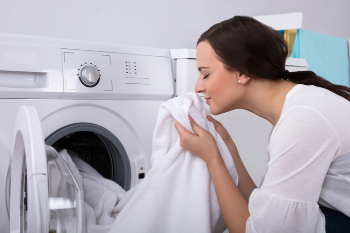 Woman Smelling Cloth After Washing In Washing Machine